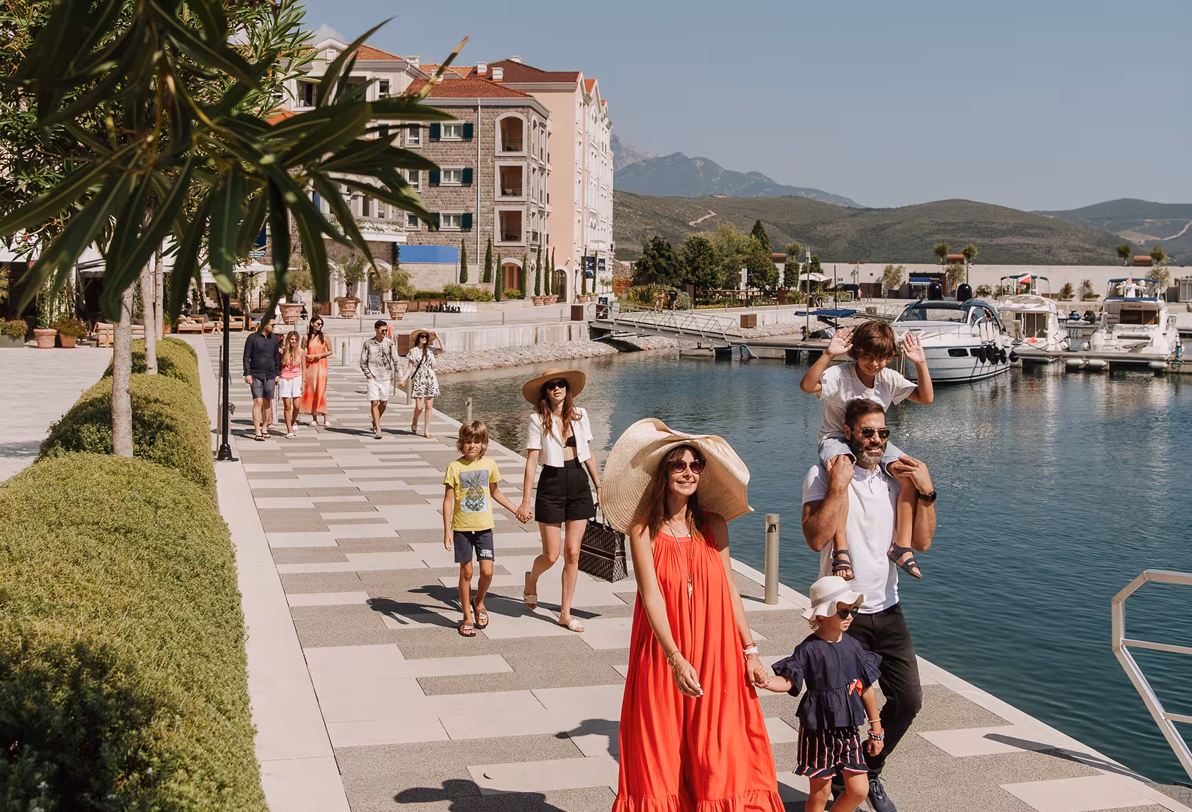 Woman walking along a seaside resort deck with lounge chairs and umbrellas
