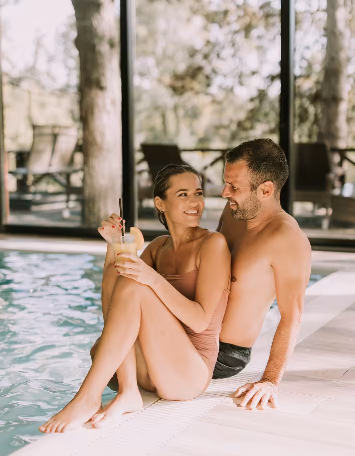 Couple sitting together by a resort swimming pool