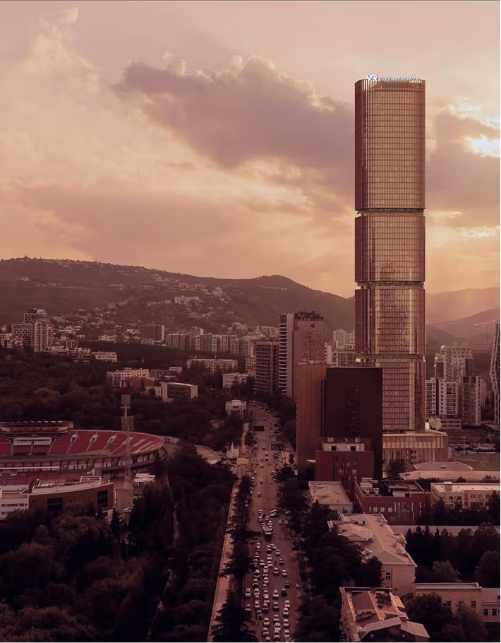 Sunset city skyline featuring a distinctive modern skyscraper